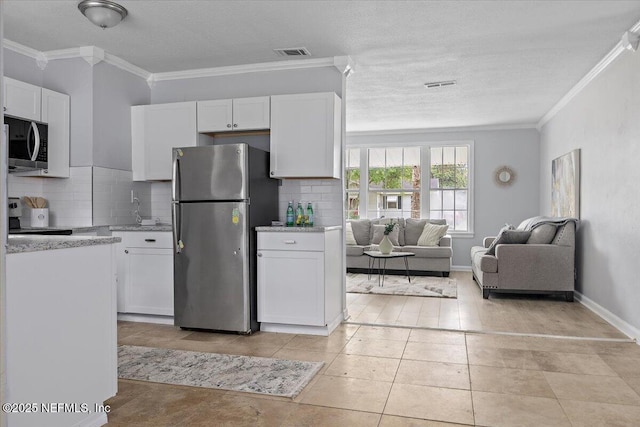 1232 Hamilton St, Jacksonville, FL 32205 - kitchen featuring tasteful backsplash, visible vents, stainless steel appliances, and white cabinets