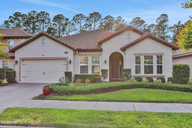 mediterranean / spanish-style home with a garage, stucco siding, driveway, and a front yard