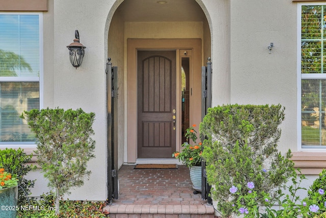 entrance to property featuring stucco siding