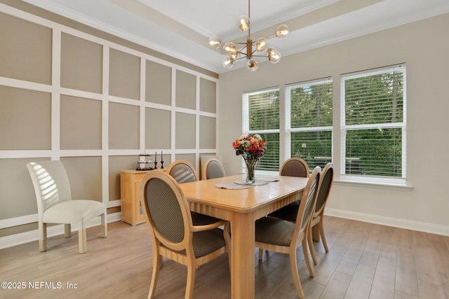 dining area featuring baseboards, ornamental molding, an inviting chandelier, and light wood finished floors