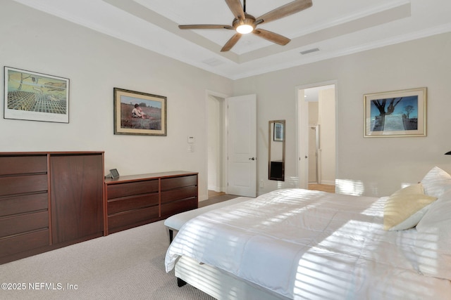 carpeted bedroom featuring visible vents, ceiling fan, crown molding, and a tray ceiling