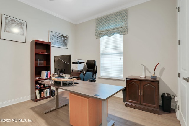 office with crown molding, a healthy amount of sunlight, baseboards, and light wood-style floors