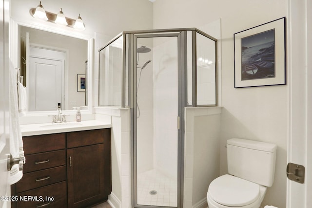 full bath with toilet, a stall shower, and vanity