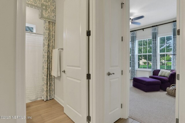 hallway featuring baseboards and light wood-style flooring