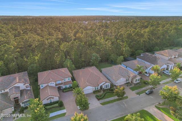 bird's eye view with a wooded view and a residential view