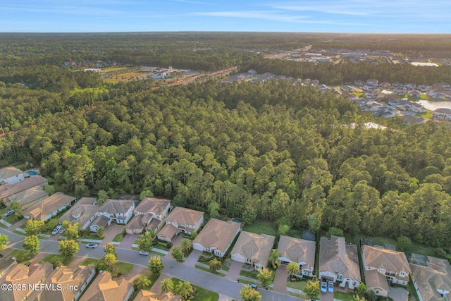 drone / aerial view featuring a residential view and a forest view