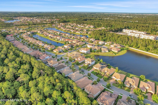 drone / aerial view featuring a residential view, a water view, and a forest view