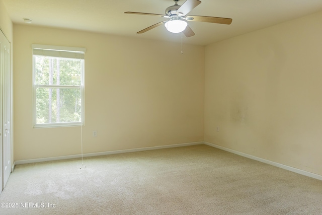 unfurnished room with baseboards, light carpet, and a ceiling fan
