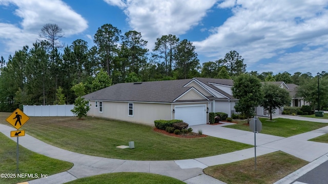 view of front facade with concrete driveway, a front yard, a garage, and fence