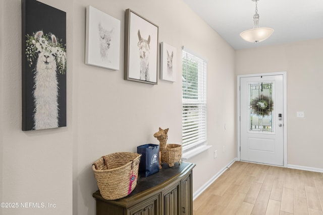entryway featuring baseboards and light wood-type flooring