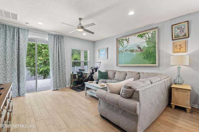 living room with a ceiling fan, recessed lighting, visible vents, and light wood-type flooring