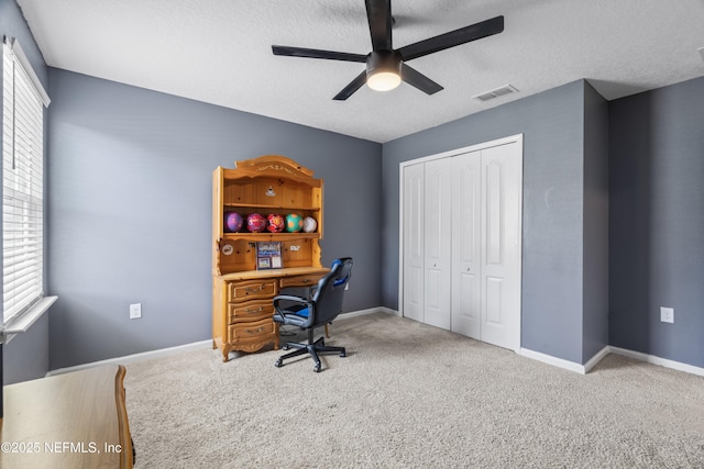 office with carpet, a healthy amount of sunlight, visible vents, and ceiling fan