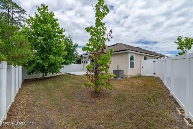 view of yard featuring central air condition unit, a patio area, and a fenced backyard
