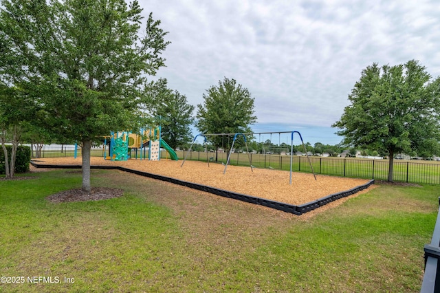 community play area with a lawn and fence