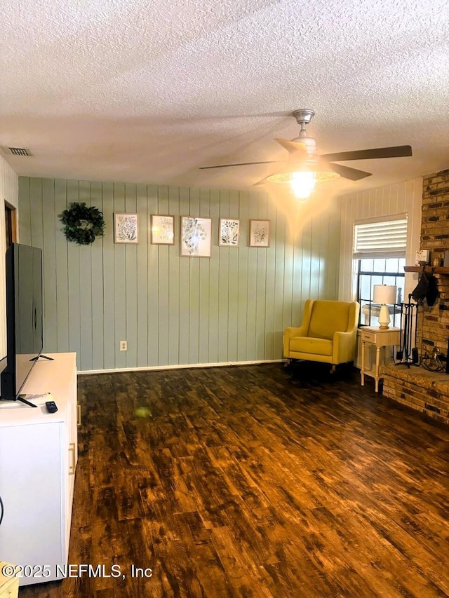 114 Timber Ln, Palatka, FL 32177 - sitting room with wood finished floors, a textured ceiling, ceiling fan, and wood walls