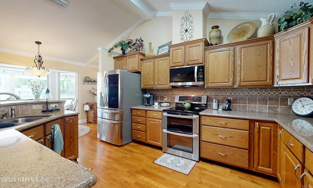 4637 Saddlehorn Trl, Middleburg, FL 32068 - kitchen featuring appliances with stainless steel finishes, a sink, decorative backsplash, hanging light fixtures, and light wood finished floors