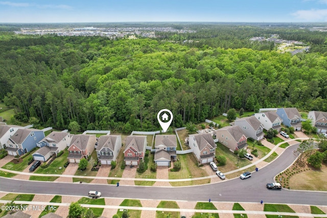 drone / aerial view with a wooded view and a residential view