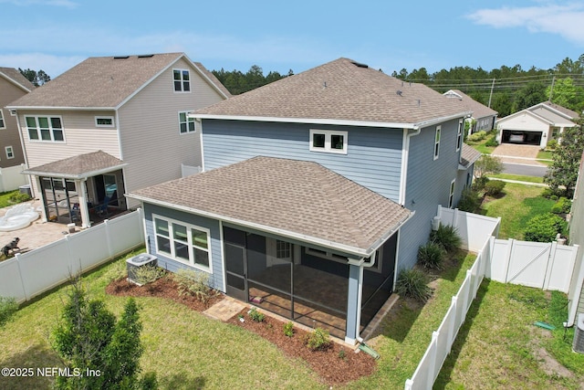 back of house with a sunroom, a shingled roof, a yard, a fenced backyard, and central AC
