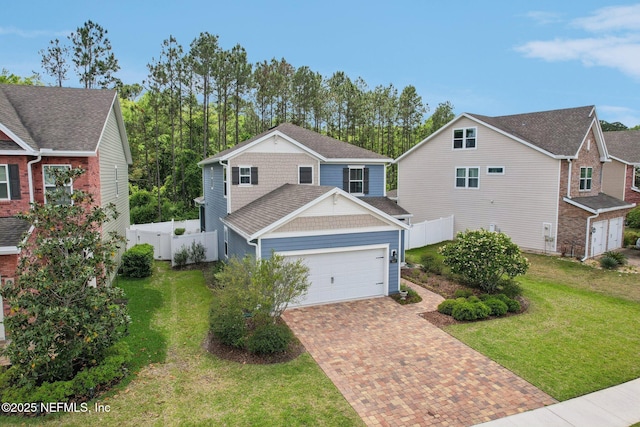traditional-style house with fence, decorative driveway, a front yard, and an attached garage