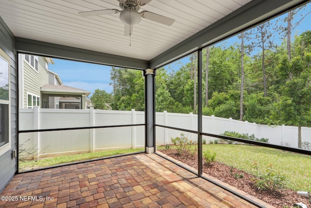 unfurnished sunroom with ceiling fan