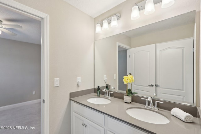 full bath with ceiling fan, double vanity, and a sink