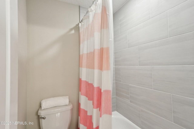 bathroom with toilet and shower / bath combo with shower curtain