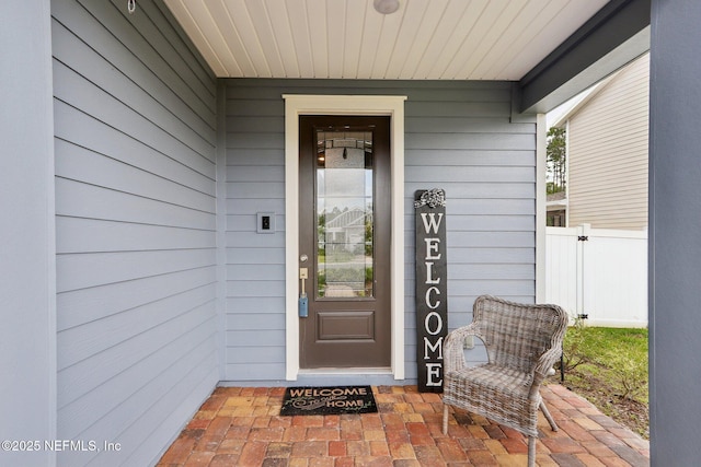 property entrance with fence and a porch
