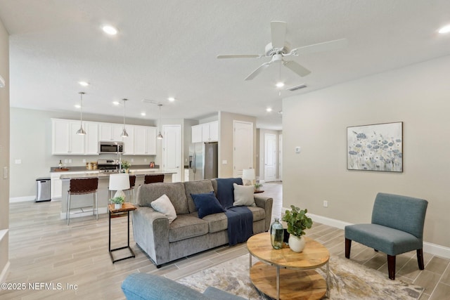 living room with wood tiled floor, ceiling fan, recessed lighting, and baseboards