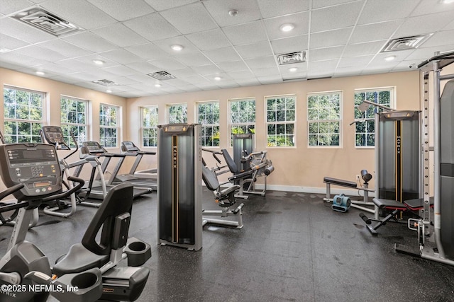 workout area featuring visible vents, a wealth of natural light, and a drop ceiling