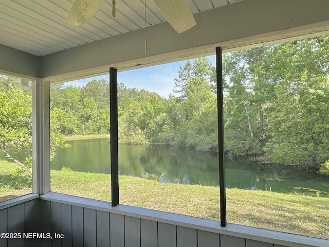 unfurnished sunroom featuring a ceiling fan and a water view