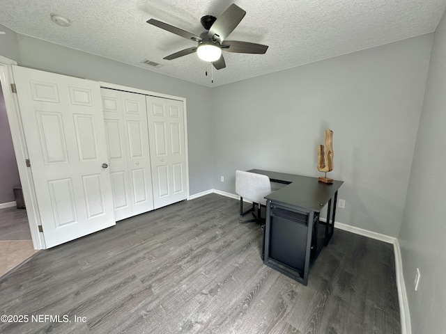 unfurnished office with visible vents, a ceiling fan, a textured ceiling, and wood finished floors