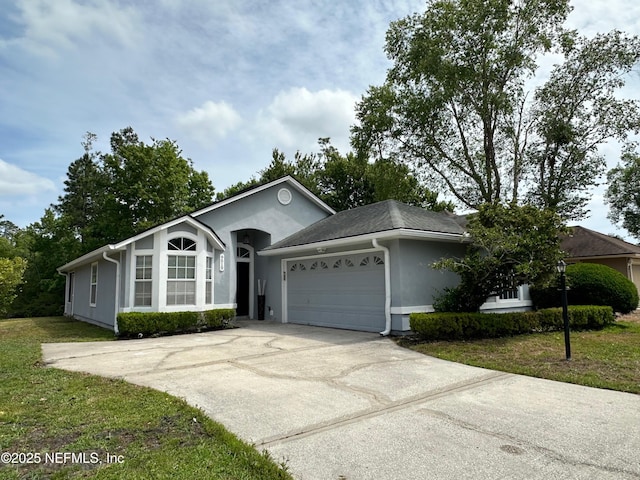 ranch-style home with an attached garage, a front lawn, stucco siding, and concrete driveway