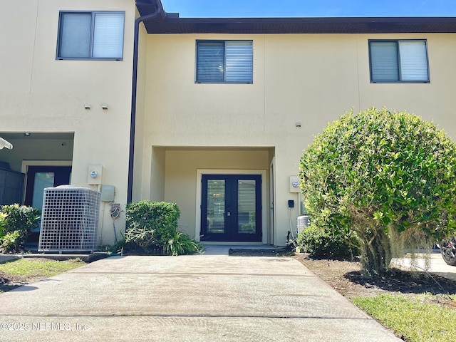 view of front of home featuring french doors, stucco siding, and central AC