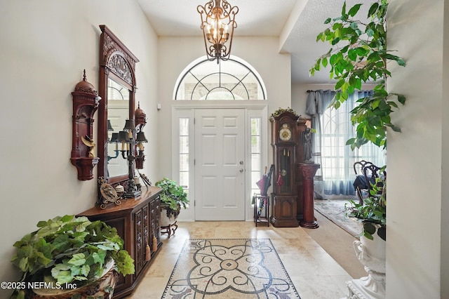 foyer entrance featuring a wealth of natural light and a chandelier