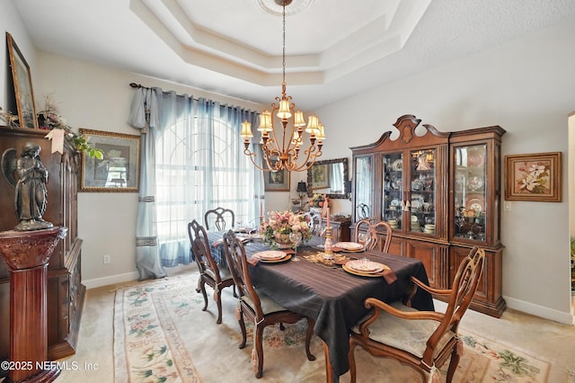 dining room with light colored carpet, a chandelier, and baseboards