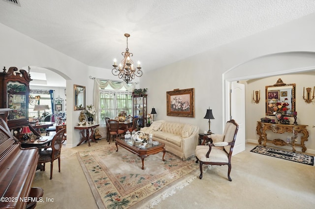 carpeted living room with an inviting chandelier, a textured ceiling, visible vents, and arched walkways
