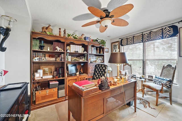 home office with light colored carpet, ceiling fan, and a textured ceiling