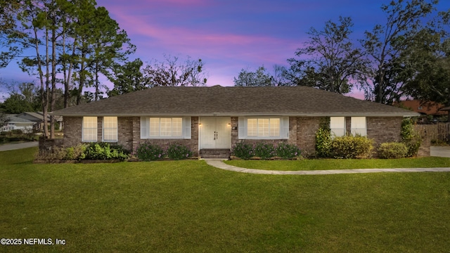 ranch-style house featuring a front lawn and brick siding