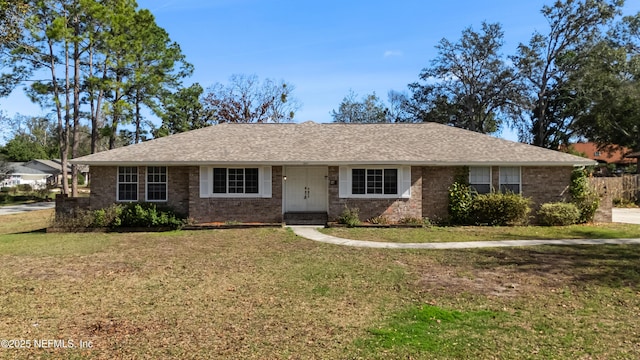 ranch-style house with brick siding, a shingled roof, and a front lawn