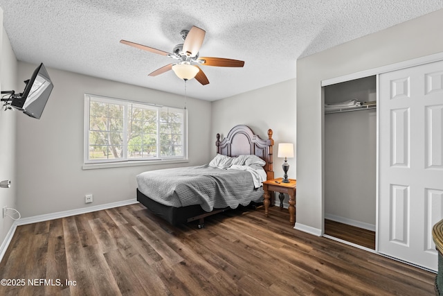 bedroom with a closet, baseboards, a textured ceiling, a ceiling fan, and dark wood finished floors
