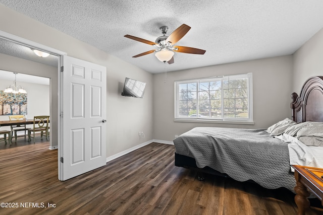 bedroom featuring baseboards, a textured ceiling, dark wood-style flooring, and ceiling fan with notable chandelier
