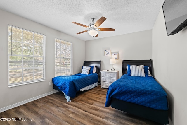 bedroom featuring baseboards, a textured ceiling, ceiling fan, and wood finished floors
