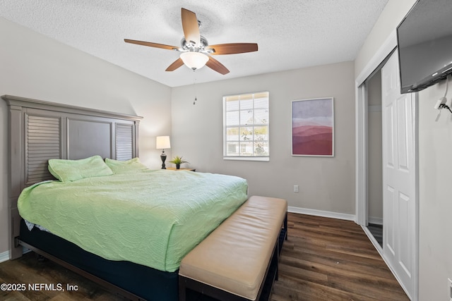 bedroom with ceiling fan, a textured ceiling, wood finished floors, baseboards, and a closet