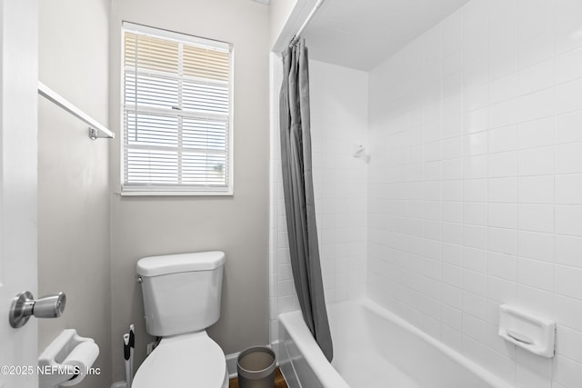 bathroom featuring shower / tub combo and toilet