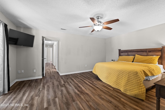 bedroom with a textured ceiling, baseboards, wood finished floors, and visible vents