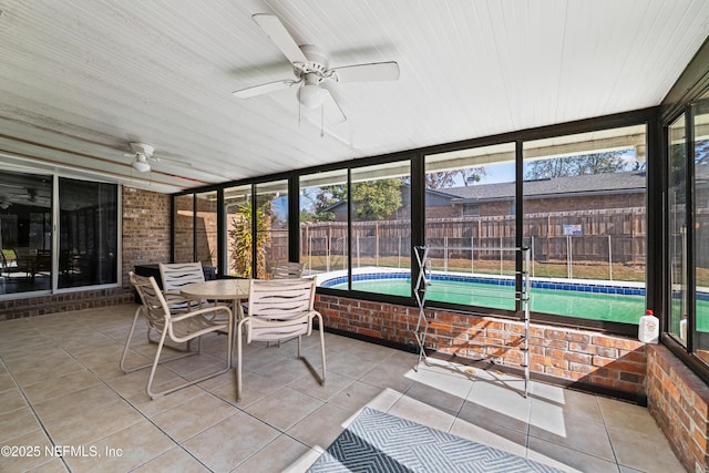 sunroom with ceiling fan and a pool
