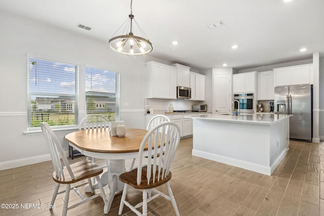 135 Neighbor Ct, Saint Augustine, FL 32092 - kitchen with an inviting chandelier, light countertops, stainless steel appliances, light wood-type flooring, and visible vents
