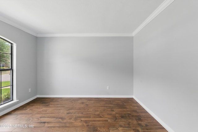 empty room with wood finished floors, ornamental molding, and baseboards