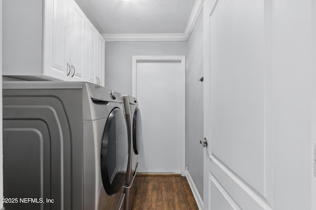clothes washing area featuring dark wood finished floors, washer and dryer, cabinet space, and crown molding