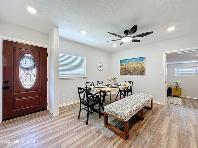 dining room featuring a ceiling fan, baseboards, a wealth of natural light, and light wood-style floors